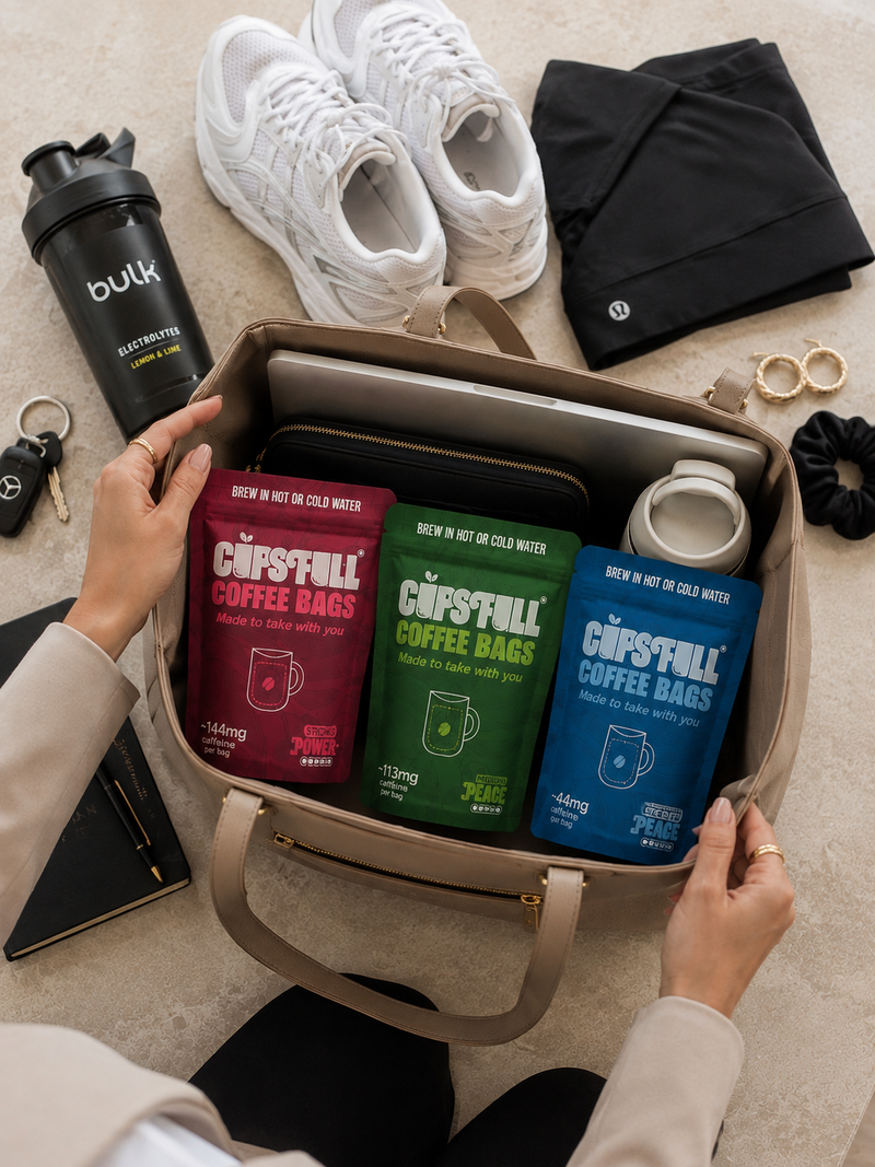 Gym bag packed with Cups Full coffee bag pouches, trainers and a water bottle