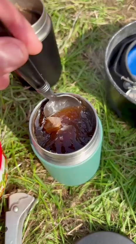 Brewing a Cups Full coffee bag in a travel cup outdoors on the grass