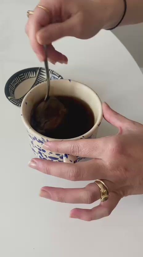 Stirring a Cups Full coffee bag in a mug